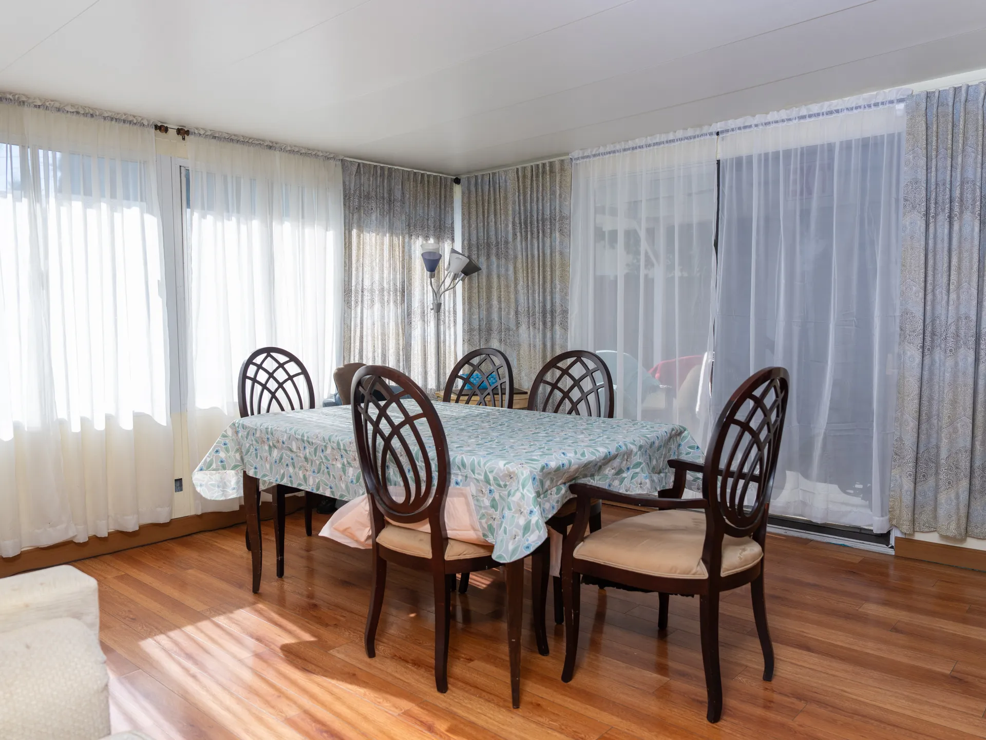 Spacious dining room with hardwood floors and large windows providing natural light for communal meals