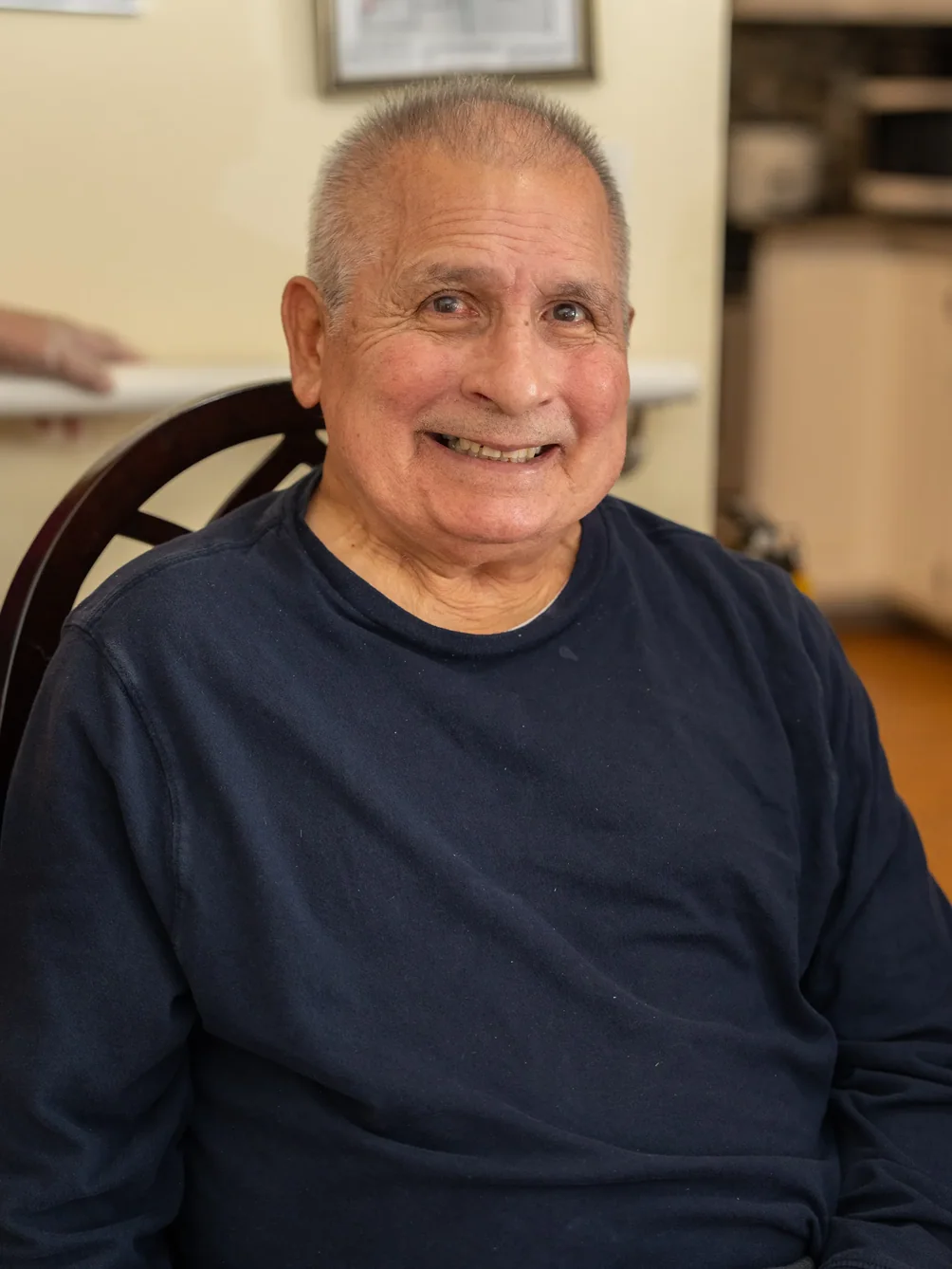 Smiling senior resident seated comfortably in residential care home