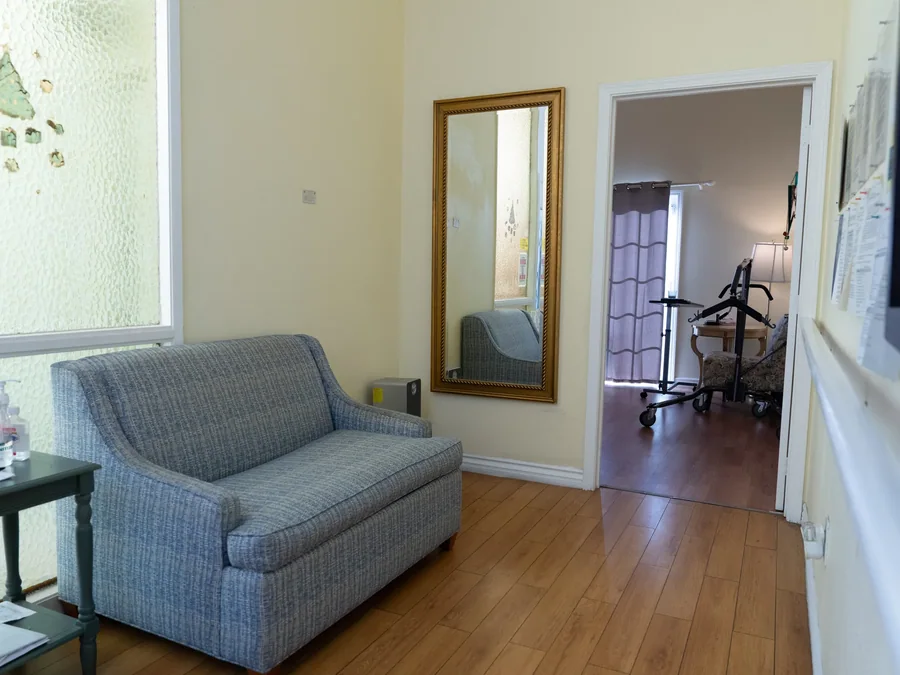 Comfortable living room with accessible bathroom entrance showing mobility equipment and home-like furnishings