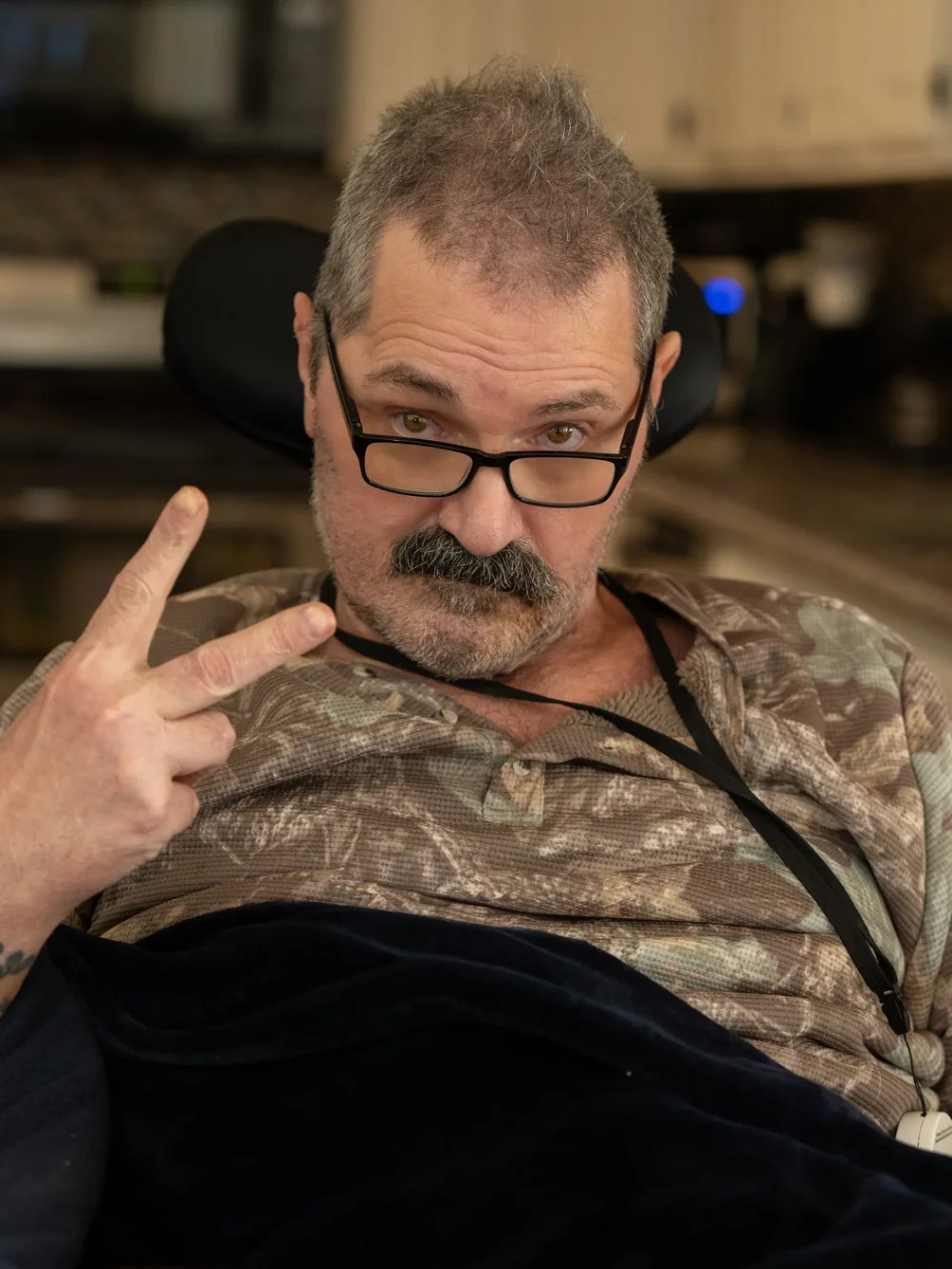 Friendly staff member in casual attire making welcoming gesture while seated in office chair